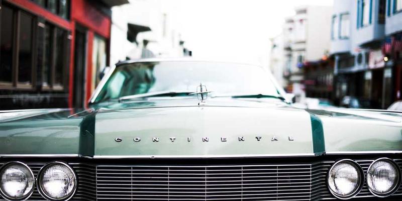 夜晚的繁华都市，街道上车辆稀少，行人穿梭，体现夜间活动的便利和效率