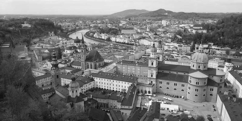 一位手工艺人在精心制作手工艺品，背景是充满现代感的都市景象，体现手工艺术与科技生活的融合