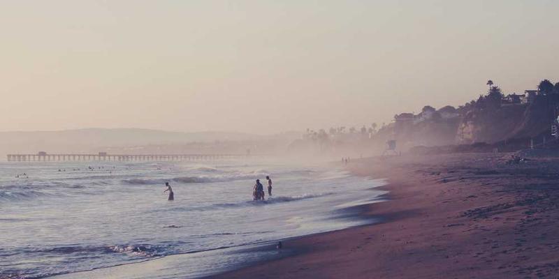 一个人在异乡街头，背对着城市的高楼，远眺远方，画面中透露出孤独与希望交织的氛围，寓意人生不同纪元的变迁